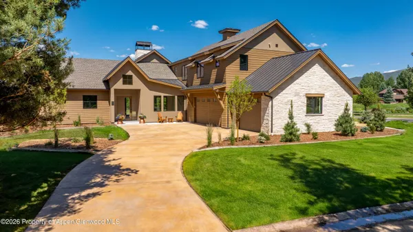 a front view of a house with a yard and potted plants