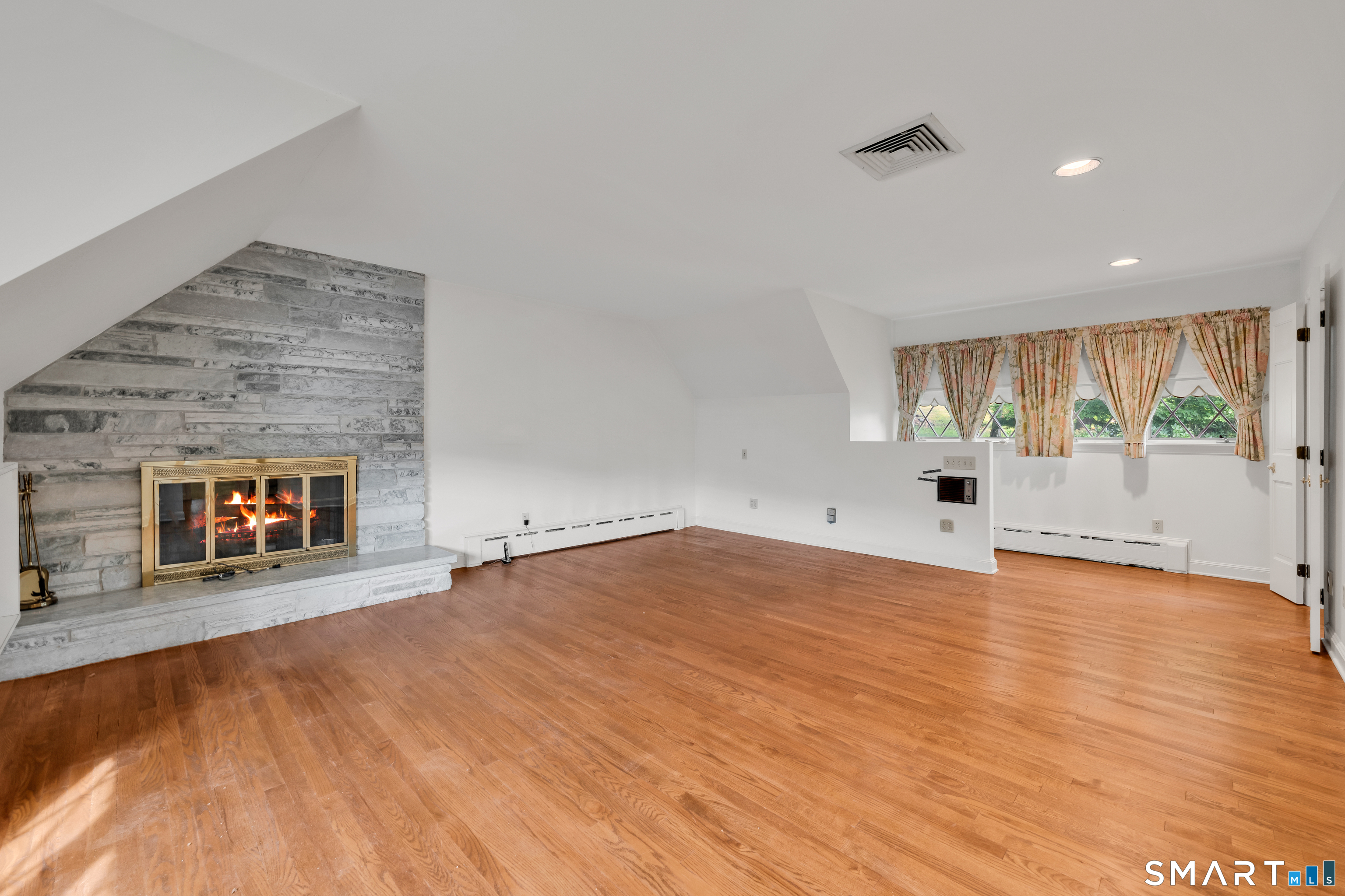 232 Maybrook Road Waterbury, CT 06708 - Photo 22 of 38 an empty room with wooden floor and fireplace