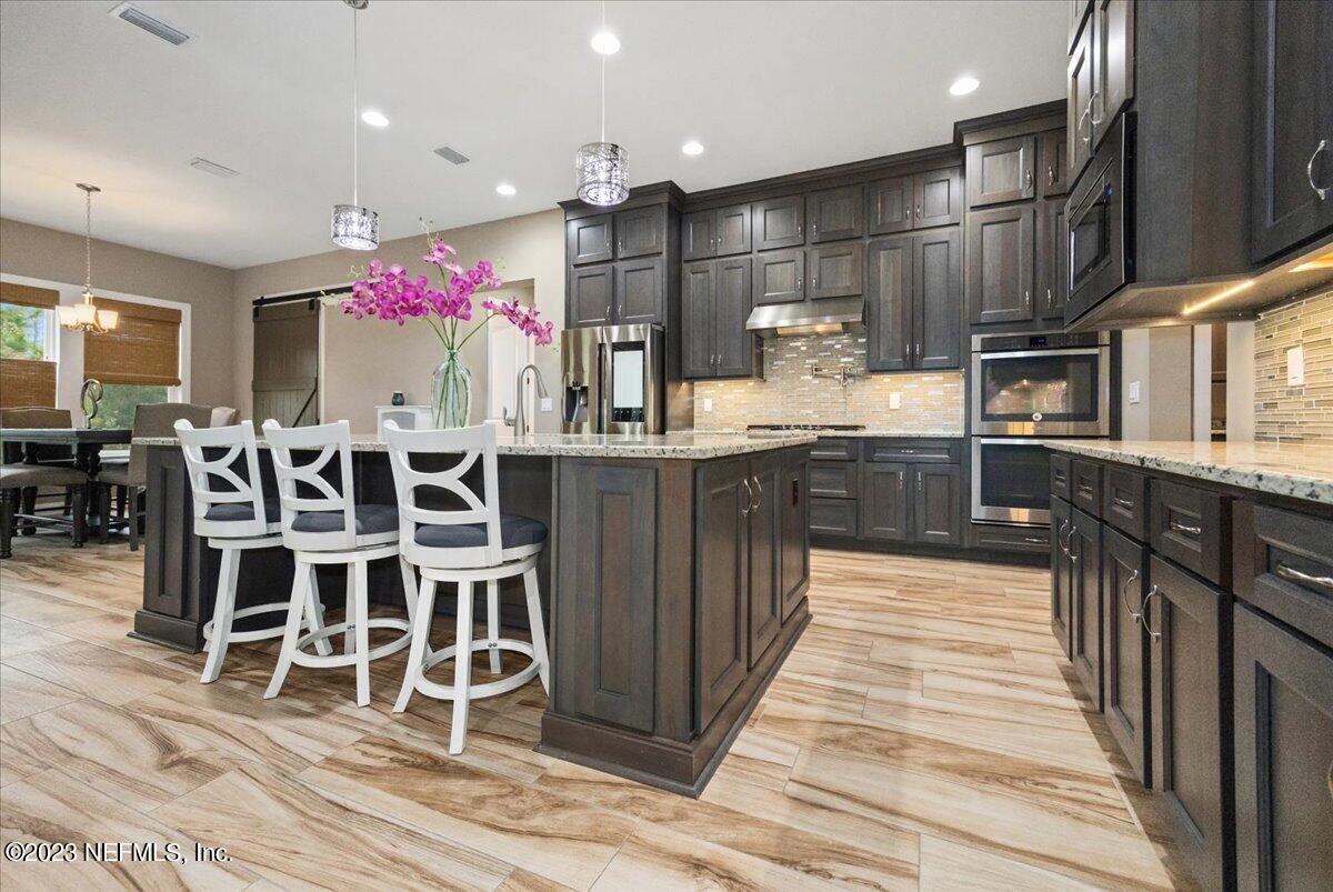 39 Seahill Drive St. Augustine, FL 32092 - Photo 8 of 37 a kitchen with stainless steel appliances kitchen island granite countertop a table chairs sink and cabinets