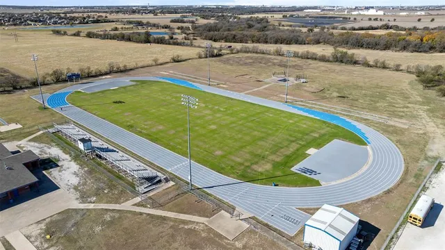 an aerial view of ocean and residential houses with outdoor space