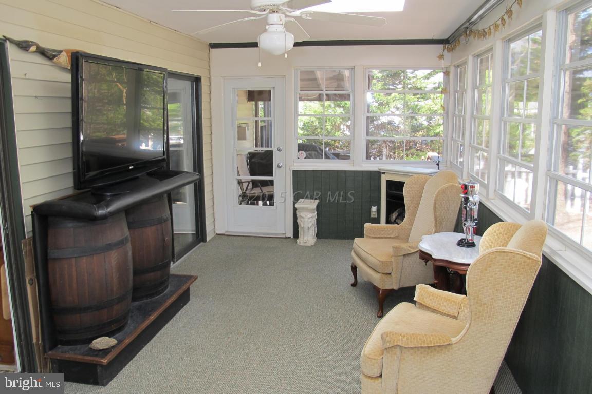 35 Falcon Bridge Road Berlin, MD 21811 - Photo 19 of 21 a living room with furniture a flat screen tv and a floor to ceiling window