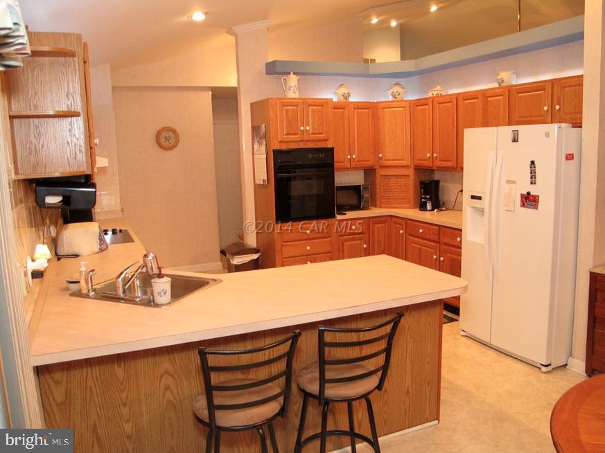35 Falcon Bridge Road Berlin, MD 21811 - Photo 8 of 21 a kitchen with stainless steel appliances a stove a refrigerator and a refrigerator with wooden floor