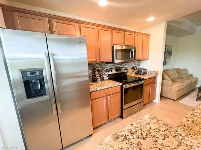 a kitchen with stainless steel appliances granite countertop a refrigerator stove and sink