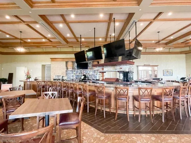 a view of a dining room with furniture a kitchen and chandelier