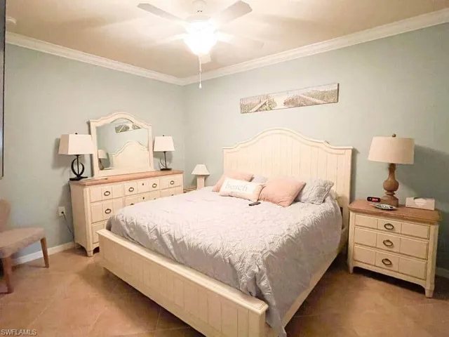 a bedroom with a bed and a lamp on dresser