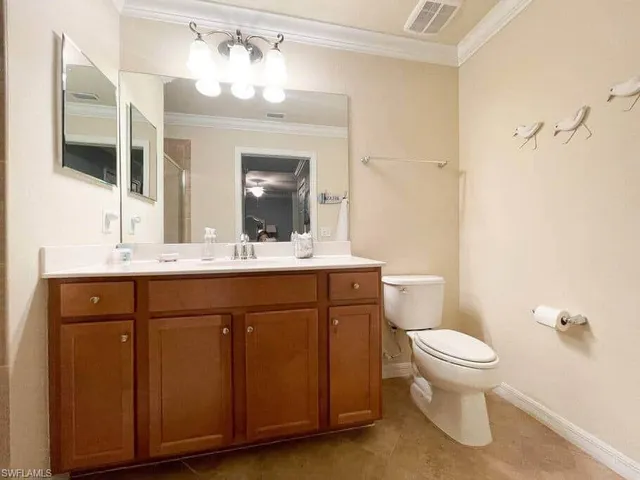 a bathroom with a sink vanity mirror and toilet