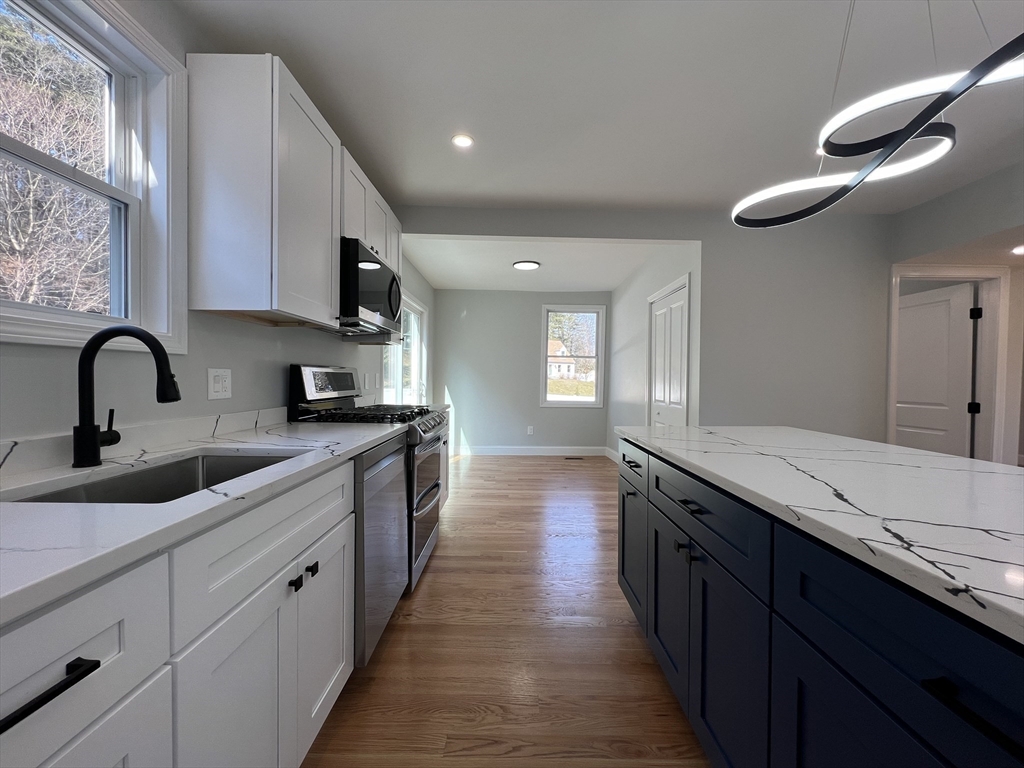 136 Old Bolton Road Stow, MA 01775 - Photo 6 of 34 a large kitchen with stainless steel appliances sink a stove and wooden floor