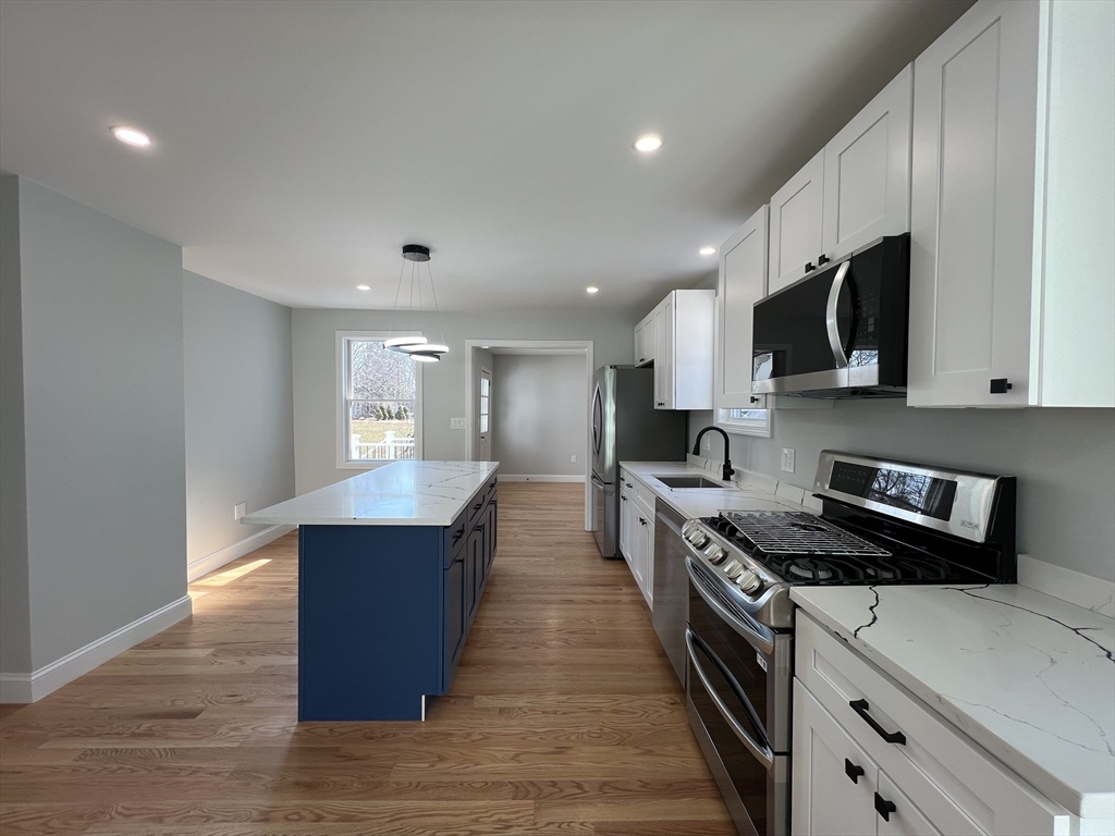 136 Old Bolton Road Stow, MA 01775 - Photo 7 of 34 a large kitchen with stainless steel appliances granite countertop a stove a sink and a microwave