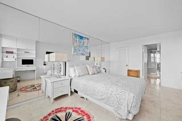 a bedroom with a bed and a lamp on the dresser