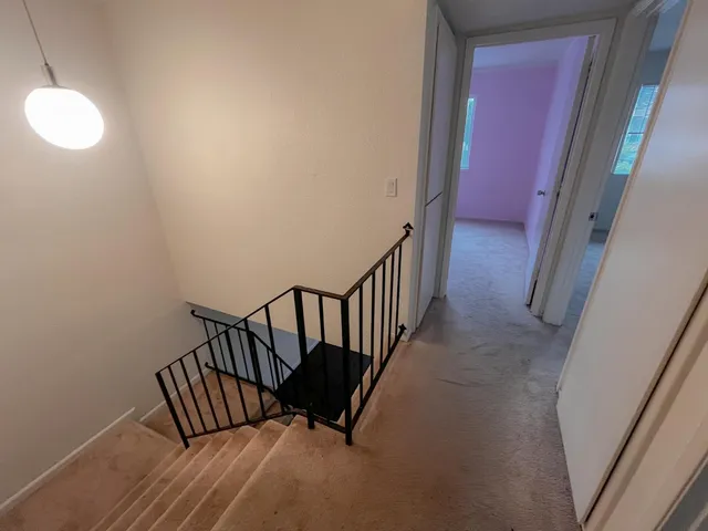 a view of a hallway with wooden floor and door