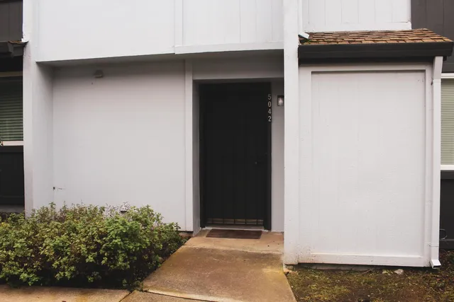 a view of a house with porch and wooden fence