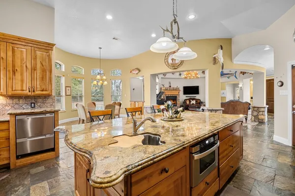 a large kitchen with granite countertop a stove and large cabinets