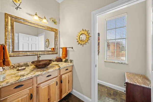 a bathroom with a granite countertop sink and a mirror