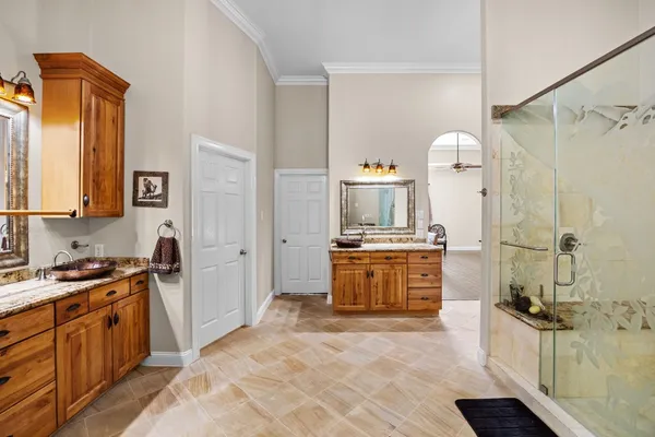 a large bathroom with a granite countertop sink a mirror a bathtub and shower