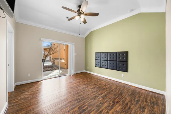 a view of an empty room with a window and wooden floor