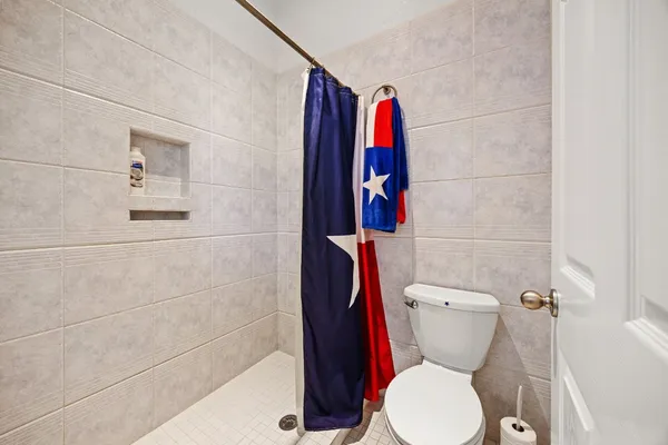a white toilet sitting next to a bathroom sink and a shower