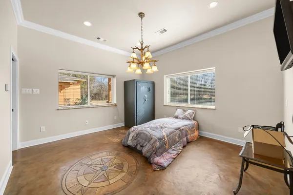 a bedroom with a bed chandelier and window
