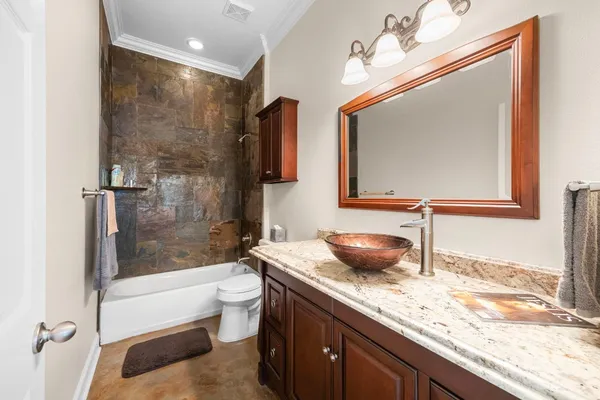 a bathroom with a granite countertop sink a mirror and a bathtub