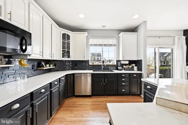 a large kitchen with stainless steel appliances granite countertop a stove a sink dishwasher and a microwave