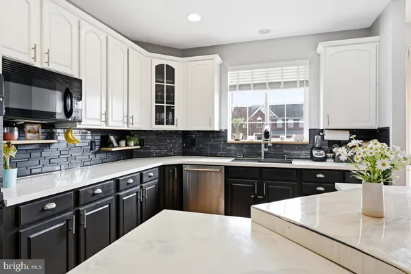 a kitchen with stainless steel appliances kitchen island granite countertop a sink a stove and cabinets