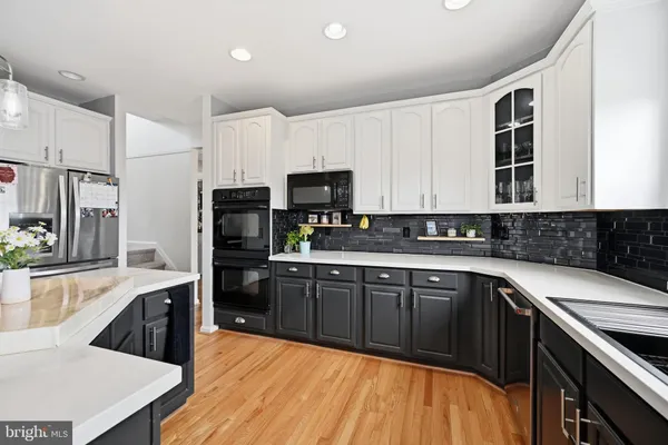 a kitchen with stainless steel appliances granite countertop a stove top oven a sink dishwasher and a refrigerator