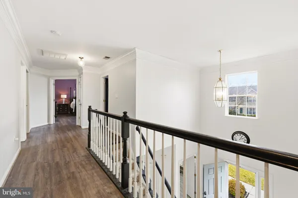 a view of a hallway with wooden floor and staircase
