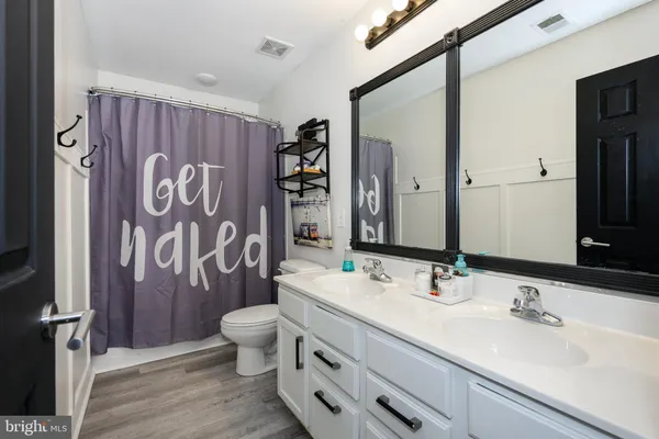 a bathroom with a sink a toilet and shower curtain
