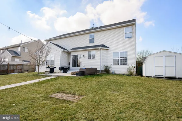 a view of a house with a big yard and large trees