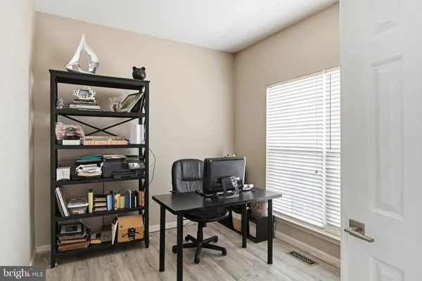 a view of a workspace with furniture and a window