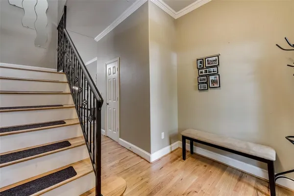 a view of a hallway with stairs and wooden floor