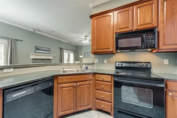 a kitchen with granite countertop a stove top oven sink and cabinets