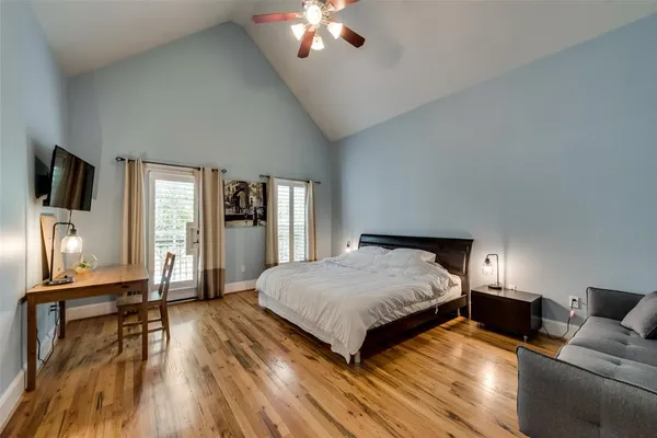 a spacious bedroom with a bed and wooden floor