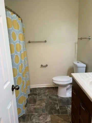 a white toilet sitting next to a shower curtain