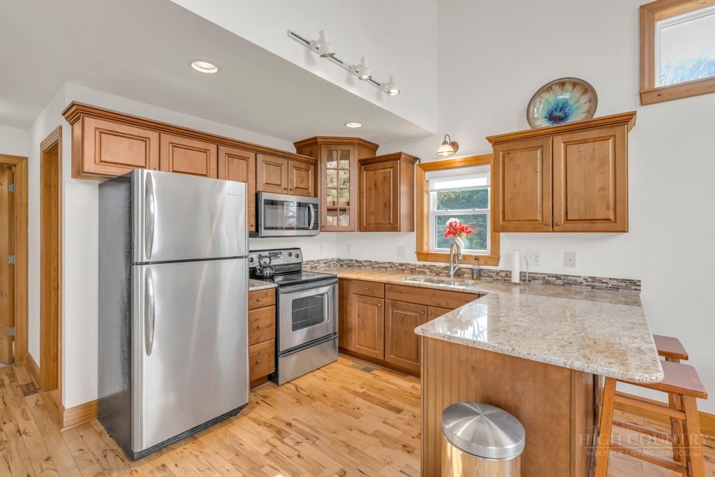 126 Knob Road Blowing Rock, NC 28605 - Photo 12 of 50 a kitchen with stainless steel appliances granite countertop a refrigerator a stove and a sink