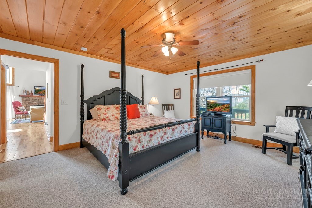 126 Knob Road Blowing Rock, NC 28605 - Photo 20 of 50 a bedroom with a bed a chandelier and balcony