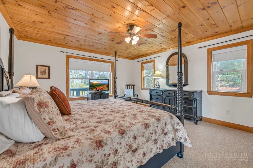 126 Knob Road Blowing Rock, NC 28605 - Photo 21 of 50 a bedroom with a large bed and a flat tv screen on dresser