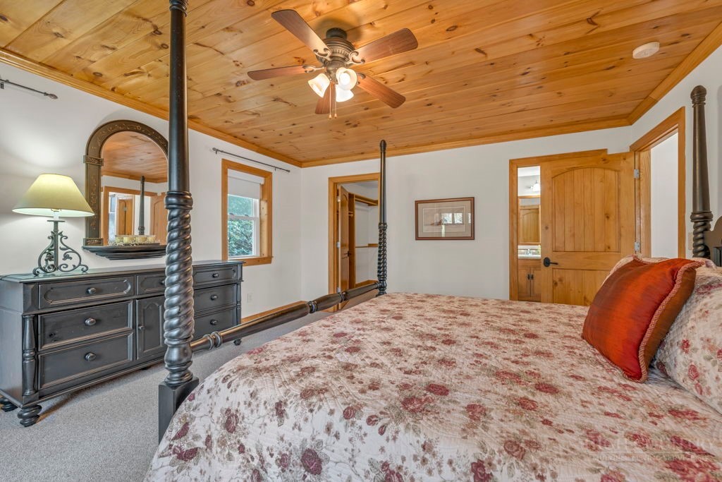 126 Knob Road Blowing Rock, NC 28605 - Photo 22 of 50 a bedroom with a bed a chandelier and dresser