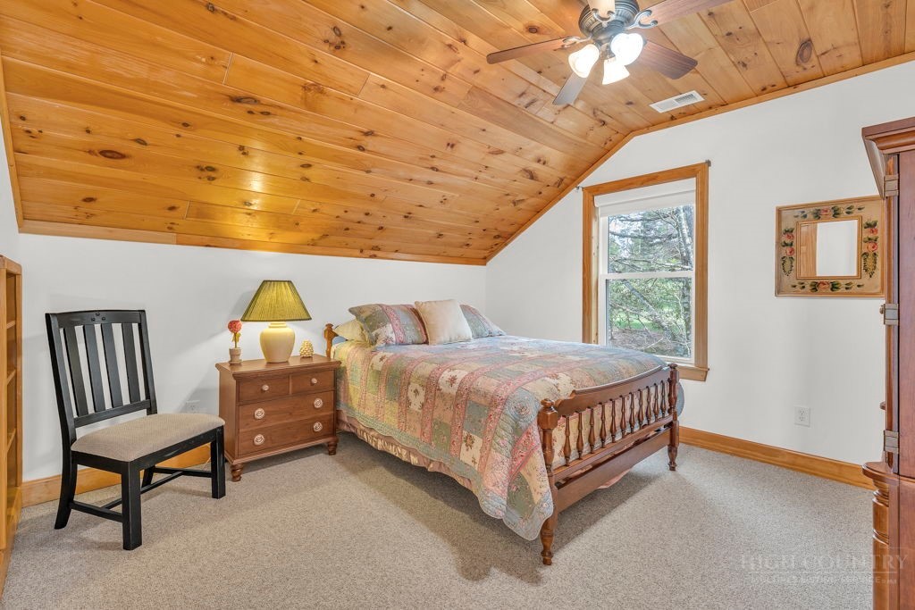 126 Knob Road Blowing Rock, NC 28605 - Photo 34 of 50 a bed room with a bed chair and a window