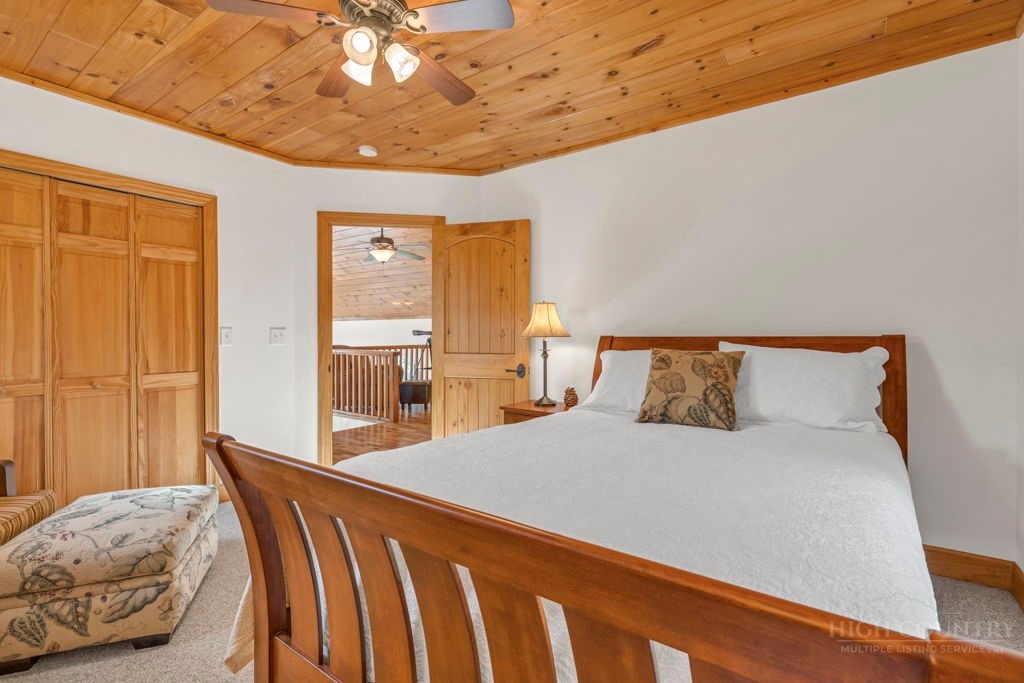 126 Knob Road Blowing Rock, NC 28605 - Photo 37 of 50 a bedroom with a large bed and a chandelier
