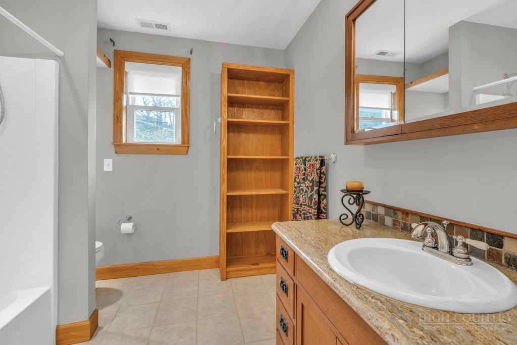 126 Knob Road Blowing Rock, NC 28605 - Photo 38 of 50 a bathroom with a sink and a mirror