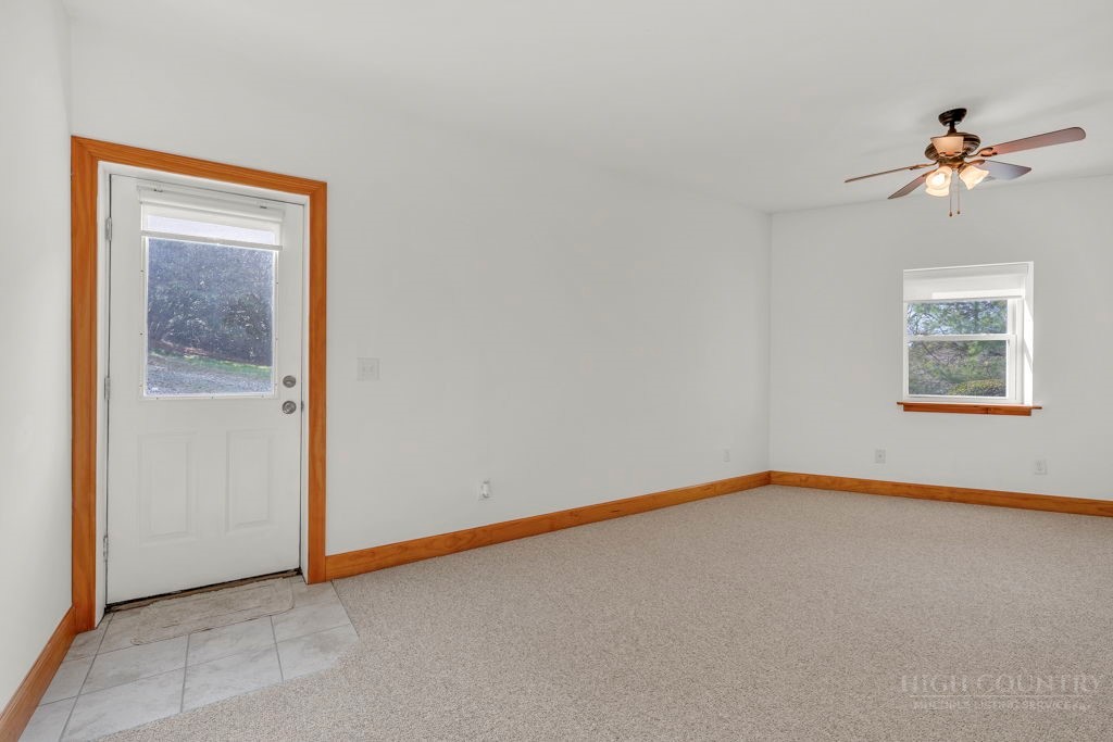 126 Knob Road Blowing Rock, NC 28605 - Photo 41 of 50 an empty room with windows and chandelier fan