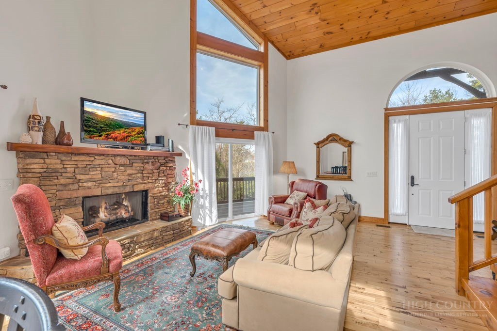 126 Knob Road Blowing Rock, NC 28605 - Photo 7 of 50 a living room with furniture a fireplace and a floor to ceiling window
