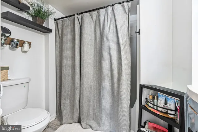 a white toilet sitting next to a bathroom