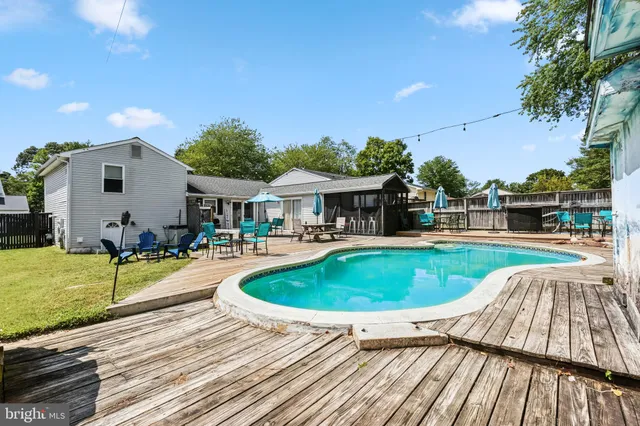 a swimming pool with outdoor seating and yard
