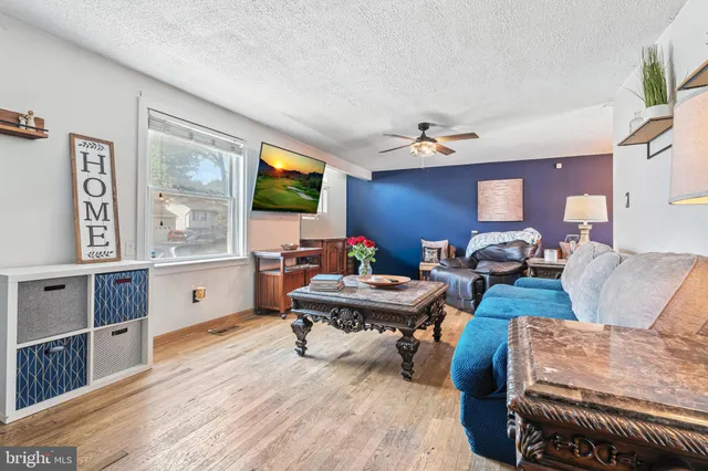 a living room with furniture a large window and a flat screen tv