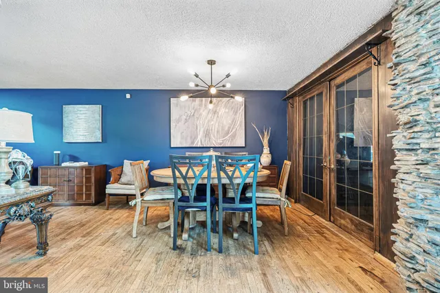 a dining room with furniture a chandelier and wooden floor