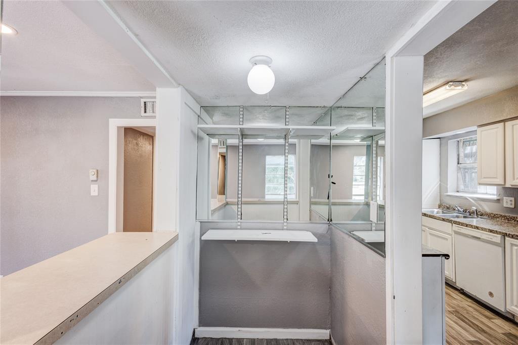 5057 Ridglea Lane, Unit 1111 Fort Worth, TX 76116 - Photo 2 of 7 a view of a hallway with wooden floor and a kitchen