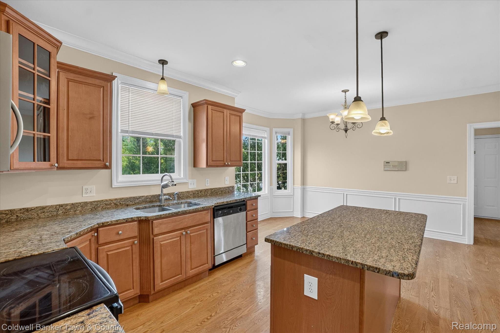 1725 Town Commons Drive Howell, MI 48855 - Photo 14 of 53 Kitchen featuring wood-finish cabinetry, granite countertops, and stainless steel appliances