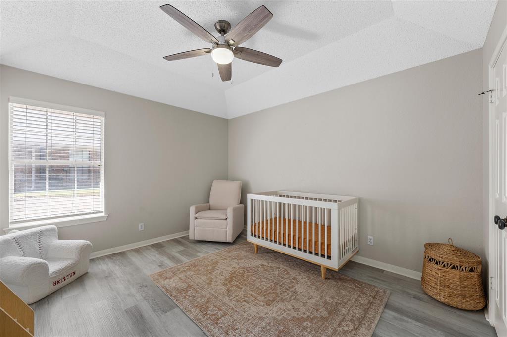 112 Briar Ridge Drive Hewitt, TX 76643 - Photo 12 of 15 Spacious room featuring a tray ceiling, ceiling fan with integrated lighting, wood-finish flooring, and a large window with blinds
