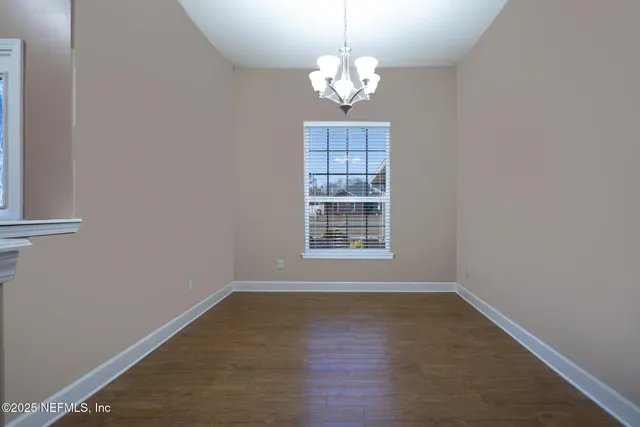 a view of livingroom with chandelier and wooden floor